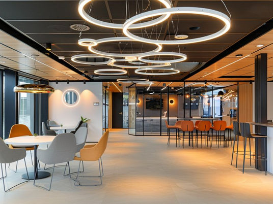 Zwarte systeemplafondplaten in houtlook met designverlichting in moderne kantoorruimte