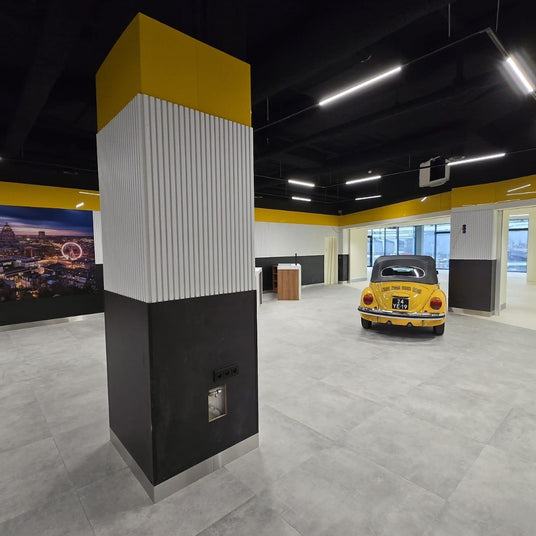 Modern bedrijfsinterieur met zwart akoestisch spuitplafond en strakke afwerking