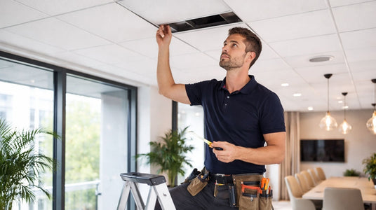 Specialist inspecteert plafondplaten in moderne zakelijke ruimte voor advies, vervanging en montage